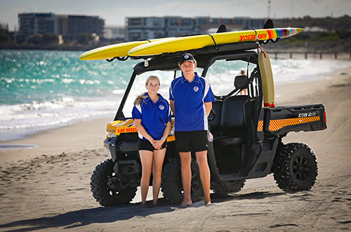Young surf life savers standing on the beach